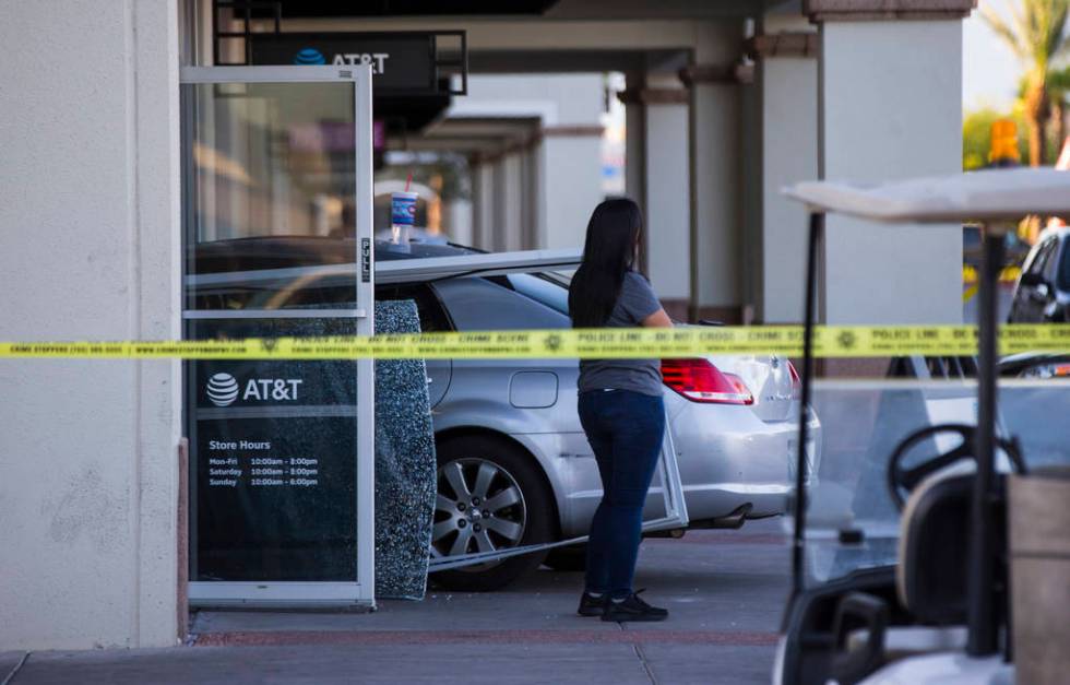 Las Vegas police investigate the scene where a driver in a car crashed into an AT&T store i ...