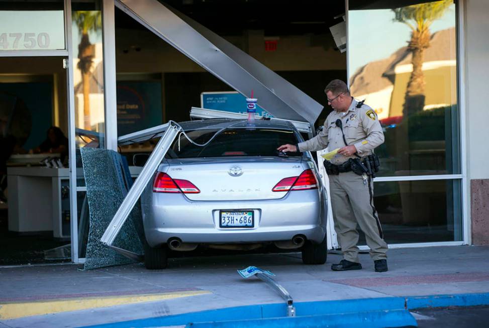 Las Vegas police investigate the scene where a driver in a car crashed into an AT&T store i ...