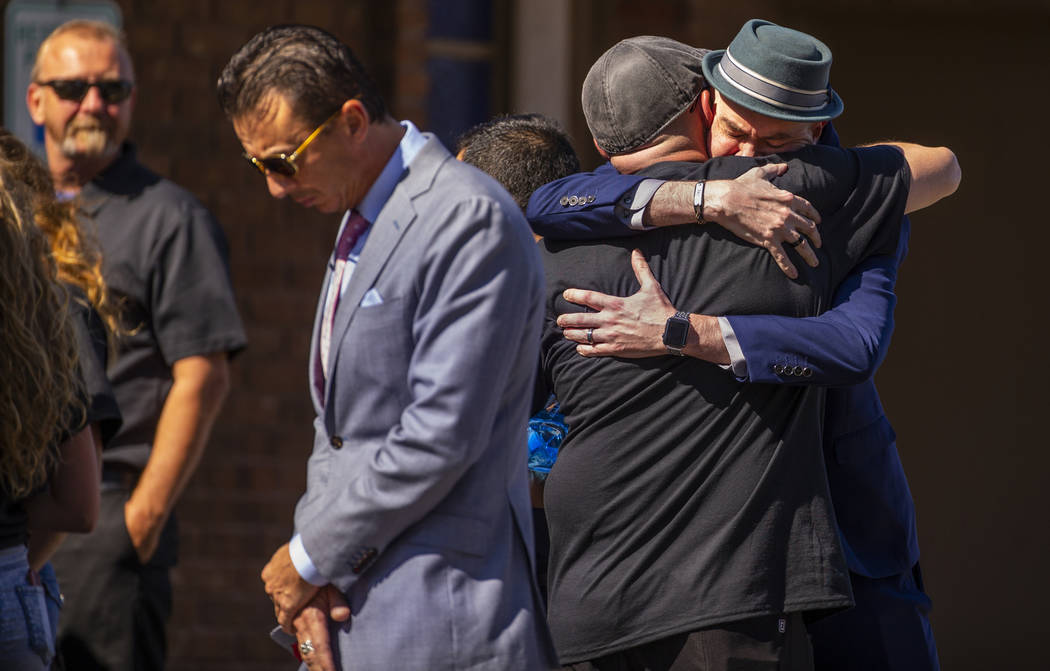 Jason Deborski, right facing away, receives a hug as mourners gather for his son Harlee Deborsk ...