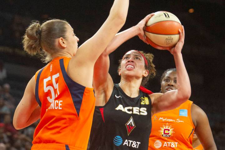 Las Vegas Aces forward Dearica Hamby, center, goes to the hoop against Connecticut Sun center T ...