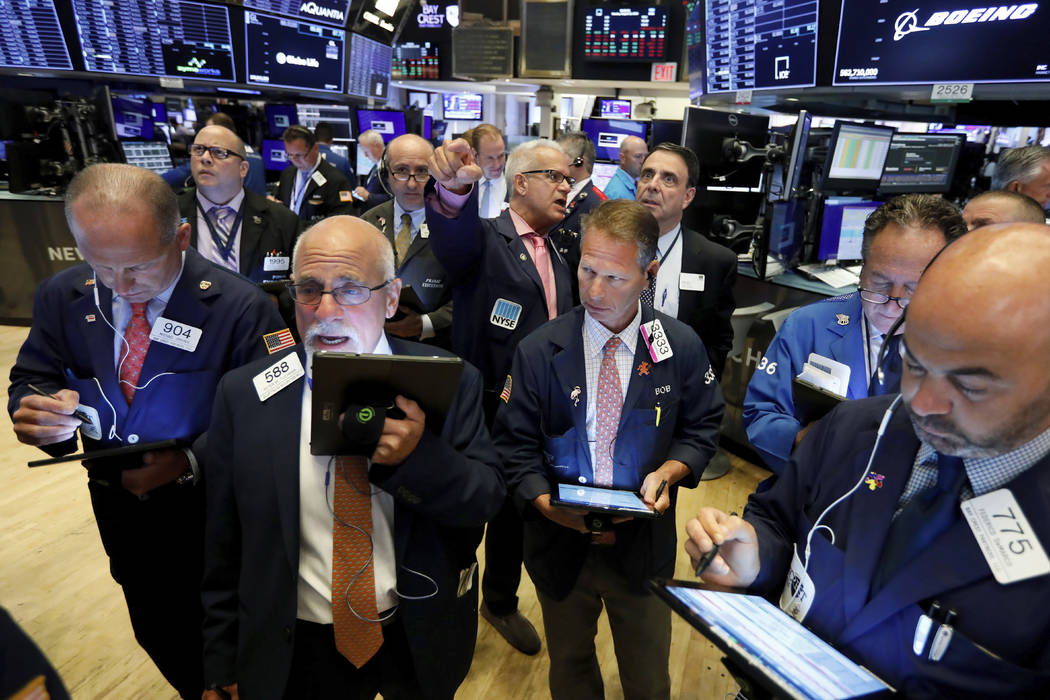 Traders work on the floor of the New York Stock Exchange, Monday, Aug. 12, 2019. Stocks are edg ...