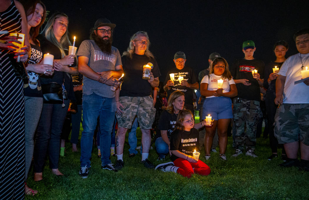 Mourners gather and say a silent prayer during a candlelight vigil for Harlee Deborski and Timo ...