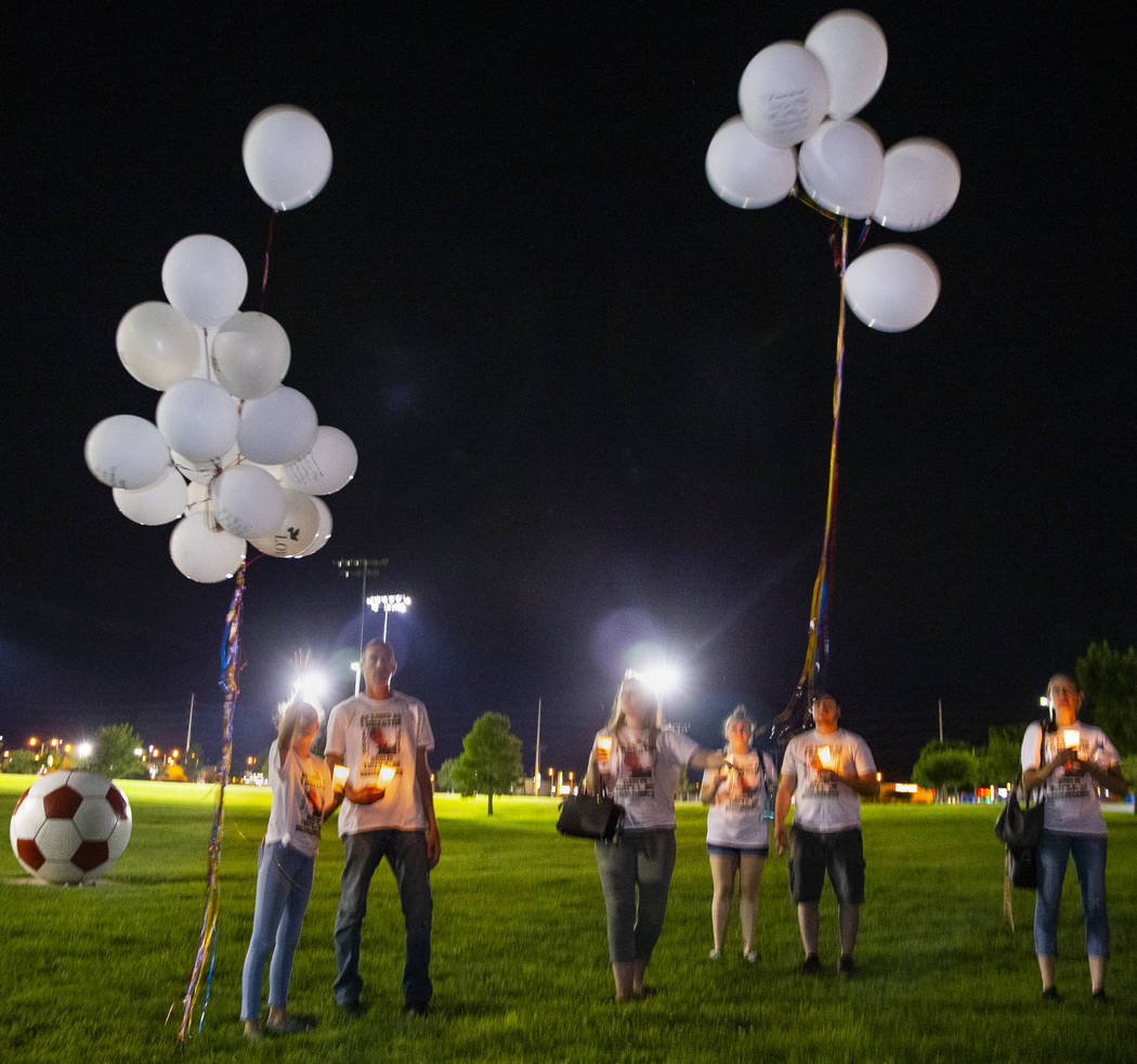 Mourners release balloons during a candlelight vigil for Harlee Deborski and Timothy Bailey at ...
