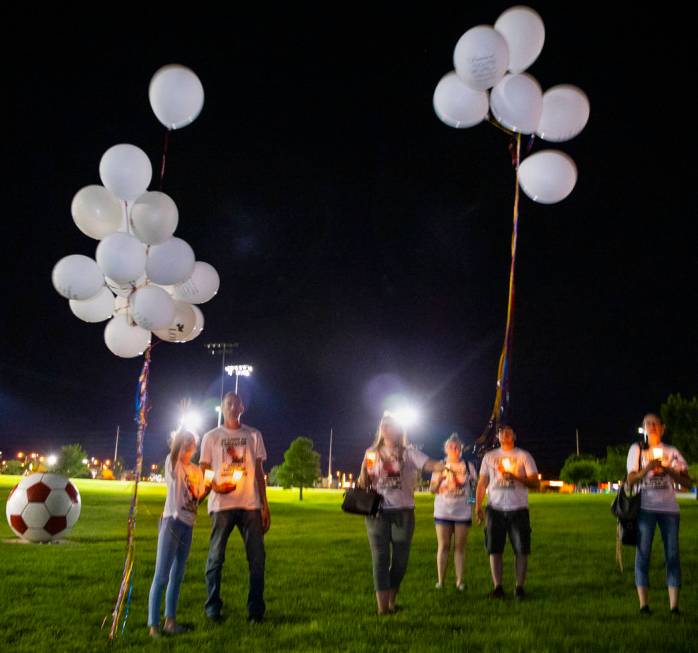 Mourners release balloons during a candlelight vigil for Harlee Deborski and Timothy Bailey at ...