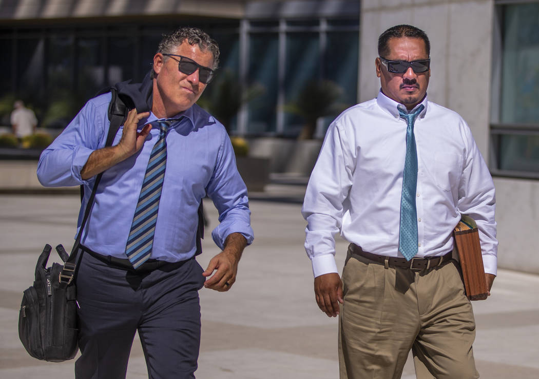 Counselor Mark Fleming, left, walks out with defendant Albert Lopez outside the Lloyd D. George ...