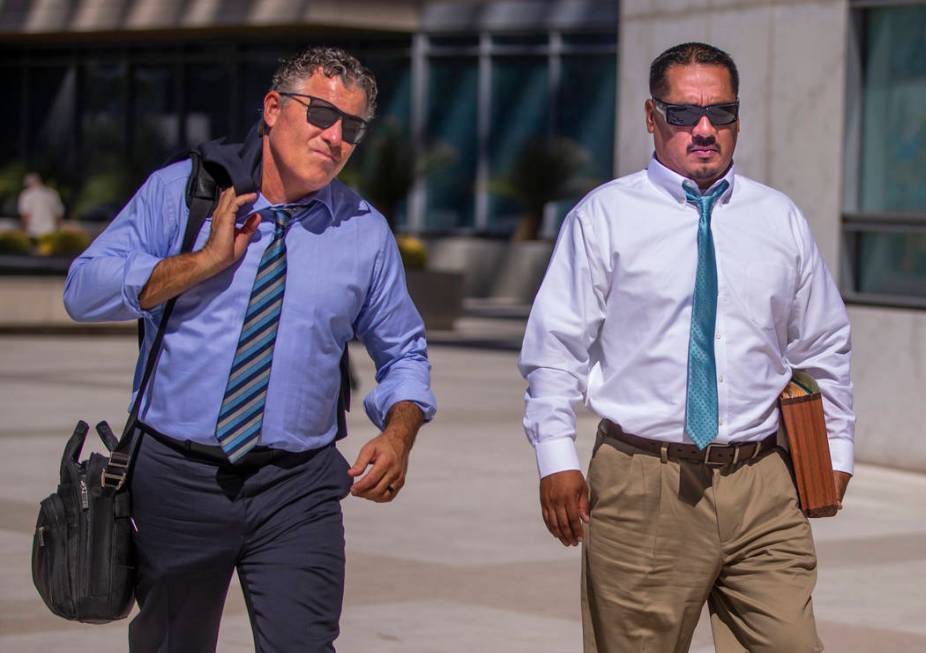 Counselor Mark Fleming, left, walks out with defendant Albert Lopez outside the Lloyd D. George ...