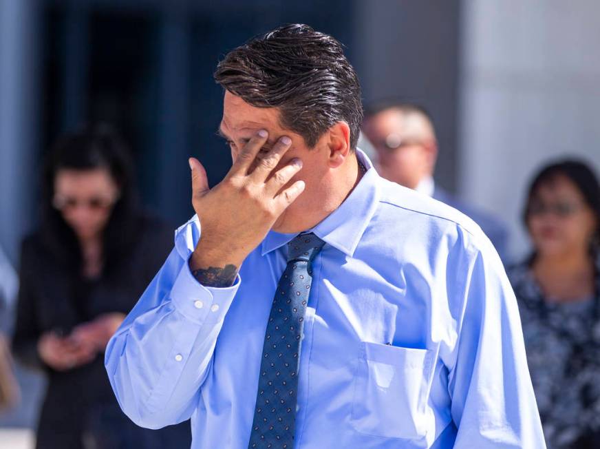 Defendant Bradley Campos hides his face while departing the Lloyd D. George Courthouse followin ...