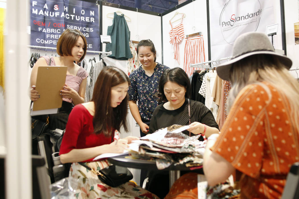 A consumer looks at fabric swatches from the Prostandard Co., LTD booth during the first day of ...