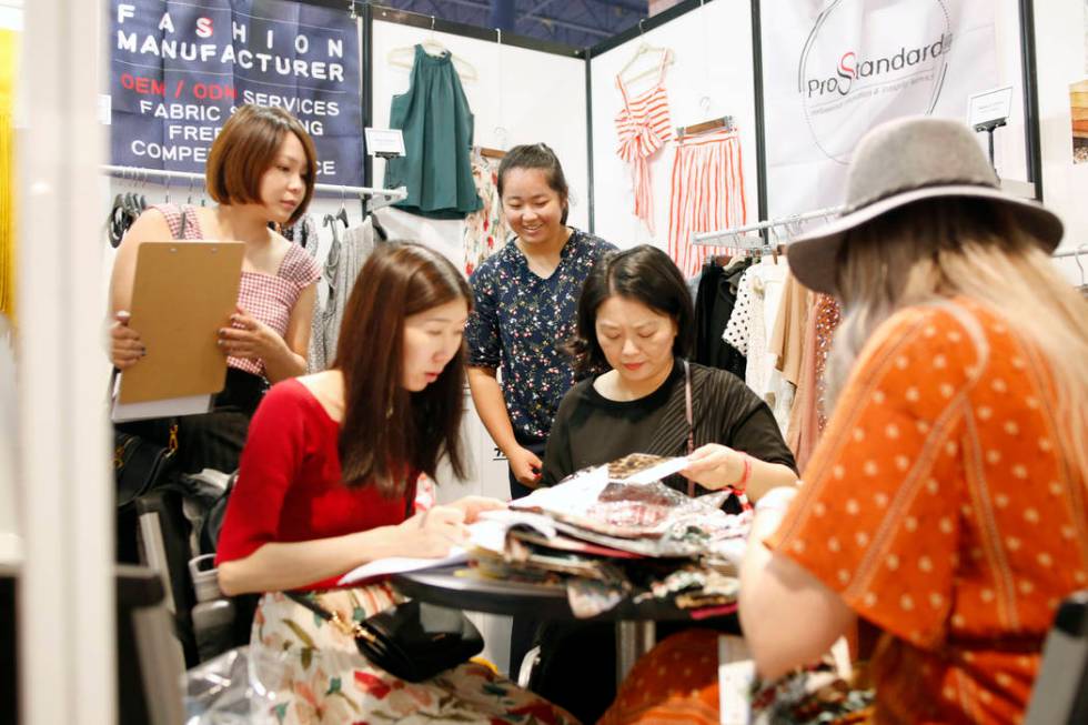 A consumer looks at fabric swatches from the Prostandard Co., LTD booth during the first day of ...