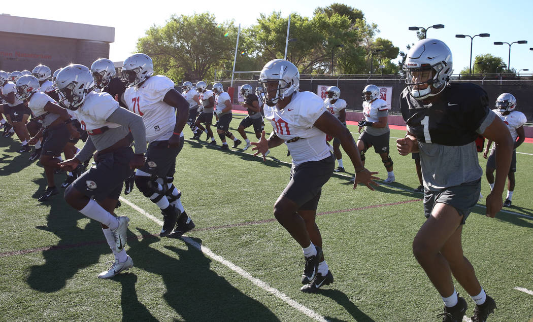 UNLV Rebels quarterback Armani Rogers (1) and wide receiver Darren Woods Jr. (10), second right ...