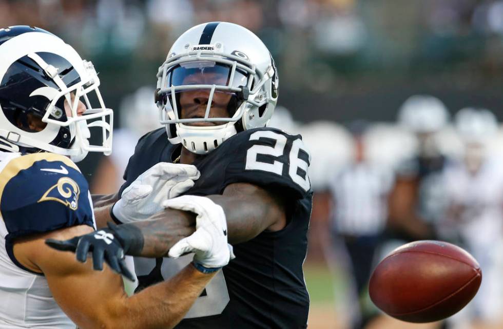 Oakland Raiders' Nevin Lawson, right, breaks up a pass intended for Los Angeles Rams' Alex Bach ...