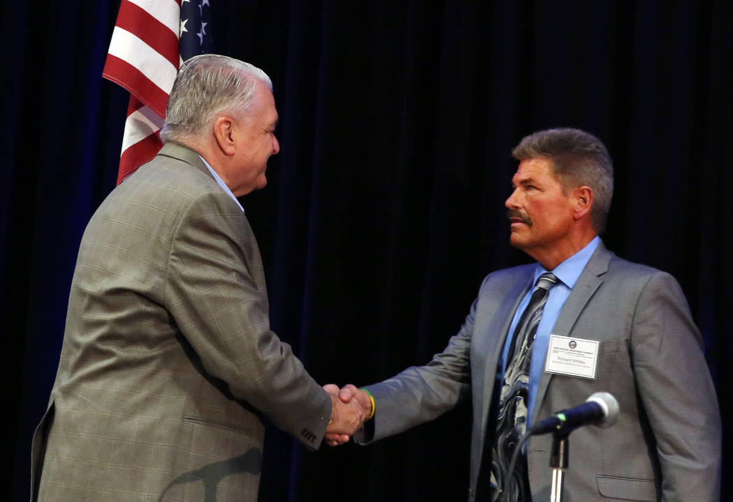 Gov. Steve Sisolak shakes hand with Richard Whitley, director of Nevada Department of Health an ...