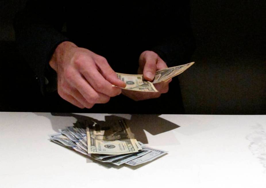 In this June 27, 2019 photo, a clerk counts money at the new sportbook at Bally's casino in Atl ...