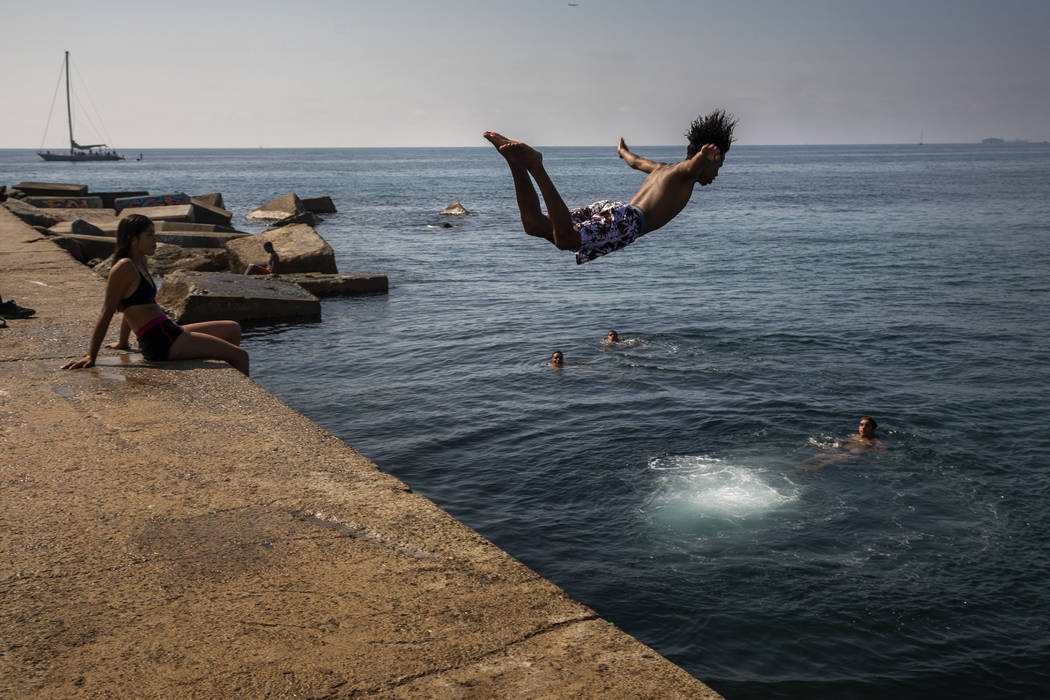 FILE - In this file photo dated Thursday, July 25, 2019, a boy jumps into the water at the beac ...