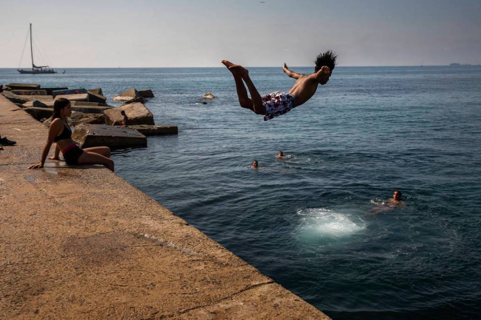 FILE - In this file photo dated Thursday, July 25, 2019, a boy jumps into the water at the beac ...