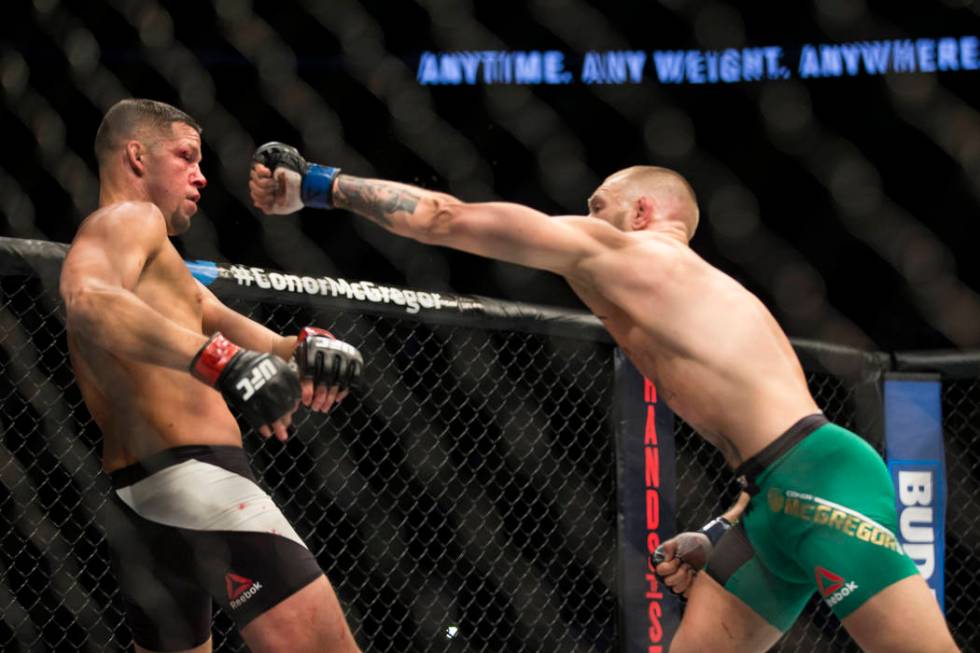 Nate Diaz, left, moves away from a punch against Conor McGregor in the welterweight bout during ...