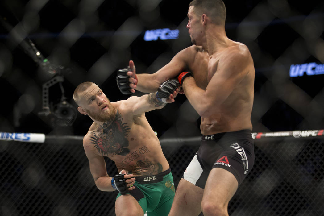 Conor McGregor, left, battles Nate Diaz in the welterweight bout during UFC 202 at T-Mobile Are ...