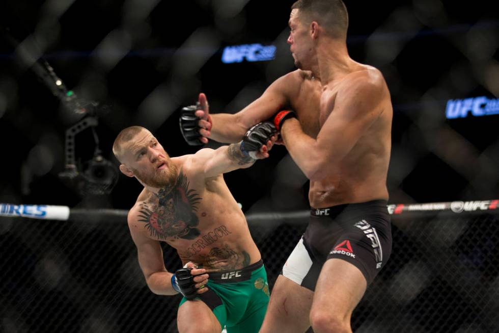 Conor McGregor, left, battles Nate Diaz in the welterweight bout during UFC 202 at T-Mobile Are ...