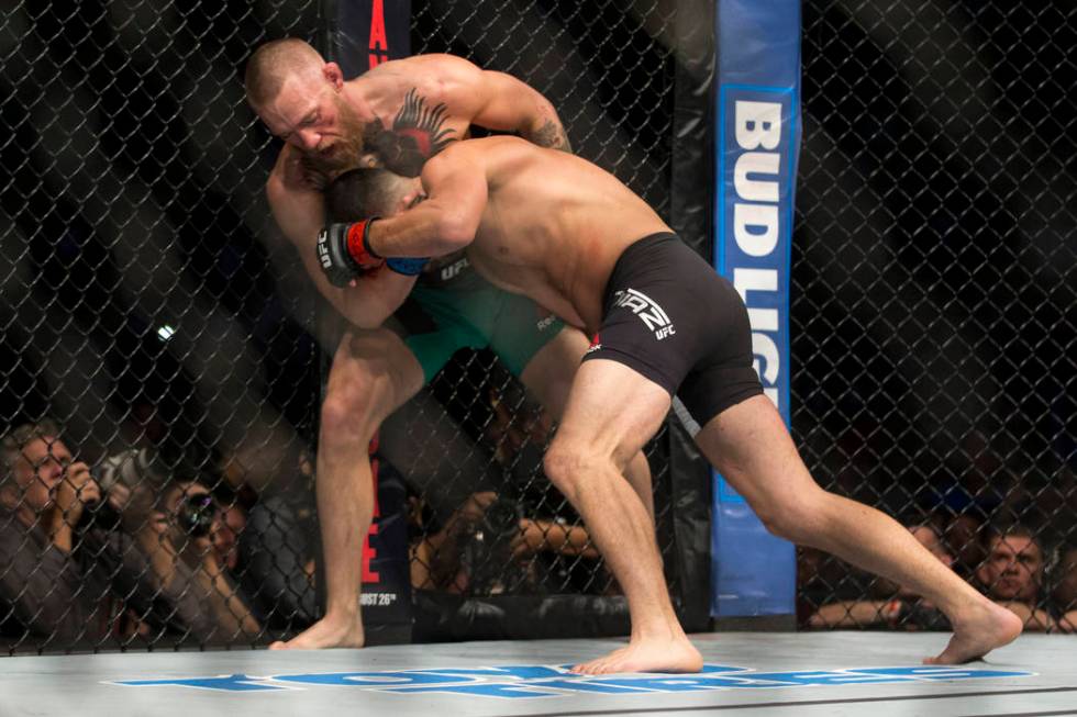 Conor McGregor, left, battles Nate Diaz in the welterweight bout during UFC 202 at T-Mobile Are ...