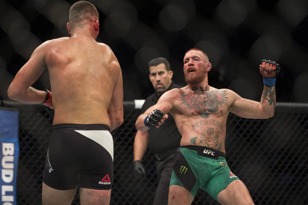 Nate Diaz, left, battles against Conor McGregor in the welterweight bout during UFC 202 at T-Mo ...