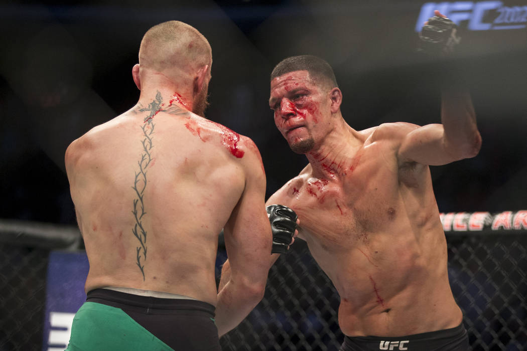 Nate Diaz, right, throws a punch against Conor McGregor in the welterweight bout during UFC 202 ...