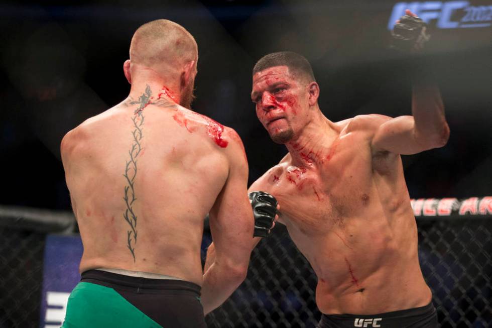 Nate Diaz, right, throws a punch against Conor McGregor in the welterweight bout during UFC 202 ...