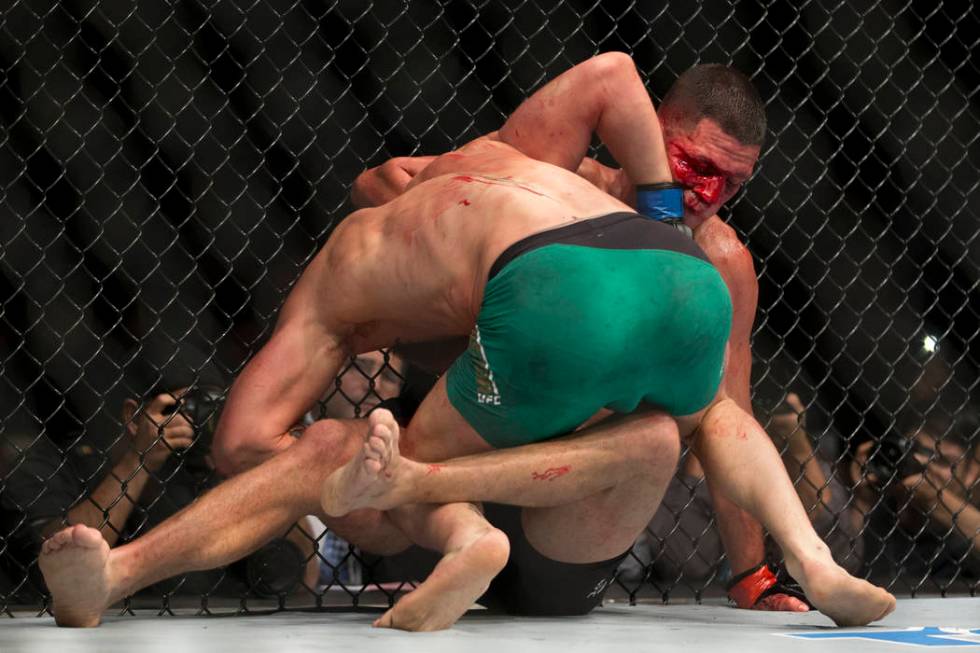 Conor McGregor, left, battles Nate Diaz in the welterweight bout during UFC 202 at T-Mobile Are ...