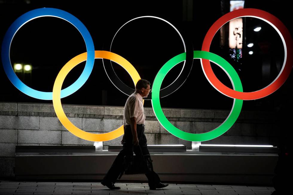 A man walks past the Olympic rings Tuesday, July 23, 2019, in Tokyo. (AP Photo/Jae C. Hong)