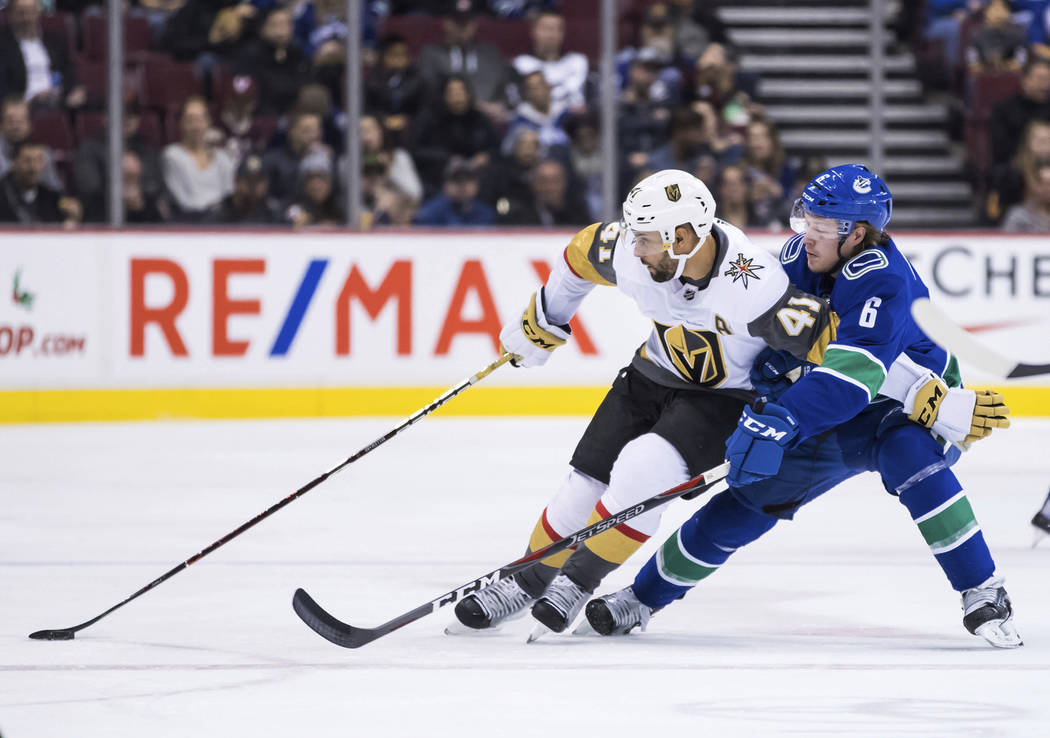 Vegas Golden Knights' Pierre-Edouard Bellemare (41) tries to hold off Vancouver Canucks' Brock ...