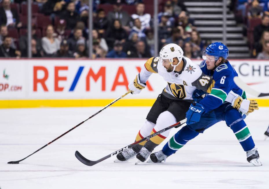 Vegas Golden Knights' Pierre-Edouard Bellemare (41) tries to hold off Vancouver Canucks' Brock ...