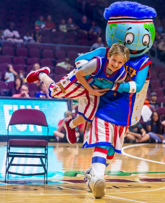 Mascot Globie, right, carries off fan Ethan Cohen, 10, while playing musical chairs as the Harl ...