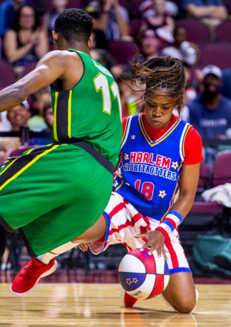 Harlem Globetrotter TNT Lister (18, right) dribbles the basketball through her legs around the ...