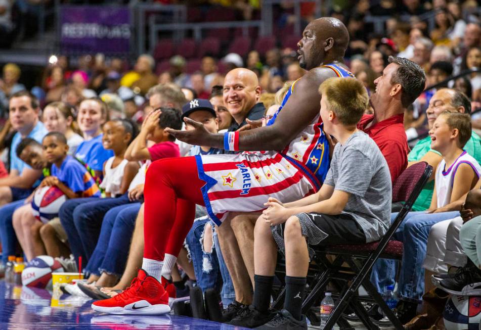 Harlem Globetrotter Big Easy Lofton (52) sits on the lap of a fan while joking around for the c ...