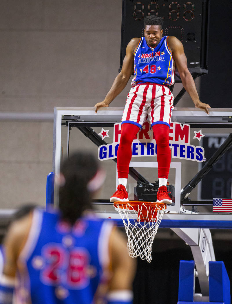 Harlem Globetrotter Clutch Ball stands atop the rim to keep the Washington Generals from scorin ...