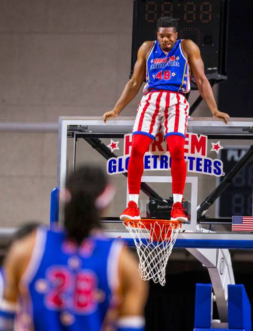 Harlem Globetrotter Clutch Ball stands atop the rim to keep the Washington Generals from scorin ...