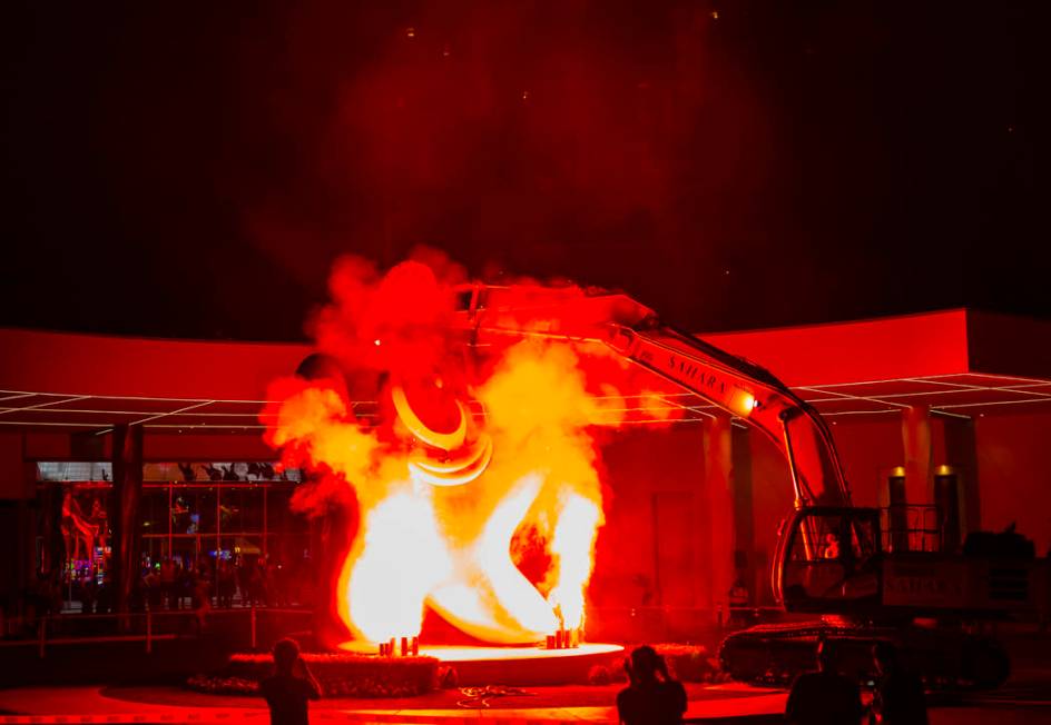 Flames shoot into the air prior to the removal of the "Sam by Starck" statue at the S ...