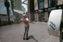 A man in a hot dog bun costume cools off in front of a misting fan on the Las Vegas Strip. (Las ...