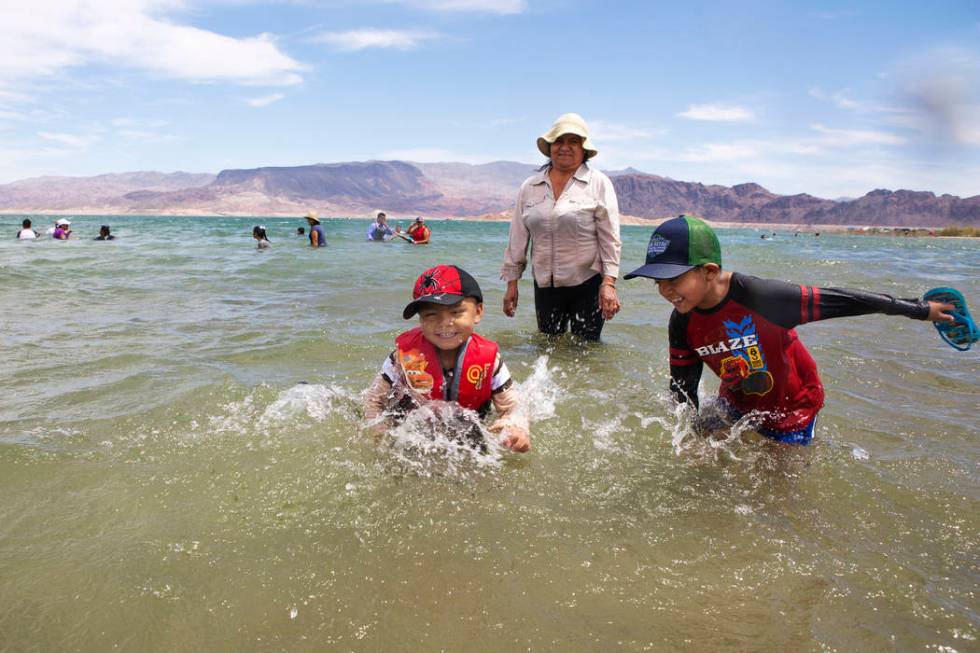 Jaiden Sanchez, 4, left, and his brother Jason, 7, right, splash in the water as their aunt Noe ...