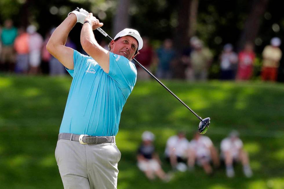 Phil Mickelson watches his tee shot on the 18th hole during the second round of the BMW Champio ...