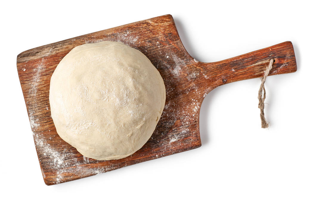 fresh raw dough on wooden board isolated on white background, top view