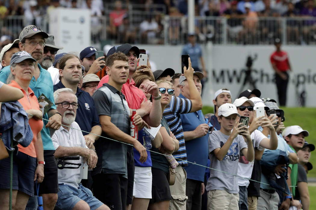 Fans watch Tiger Woods' tee shot on the 13th hole during the final round of the BMW Championshi ...