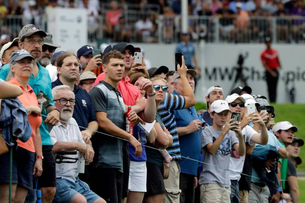 Fans watch Tiger Woods' tee shot on the 13th hole during the final round of the BMW Championshi ...