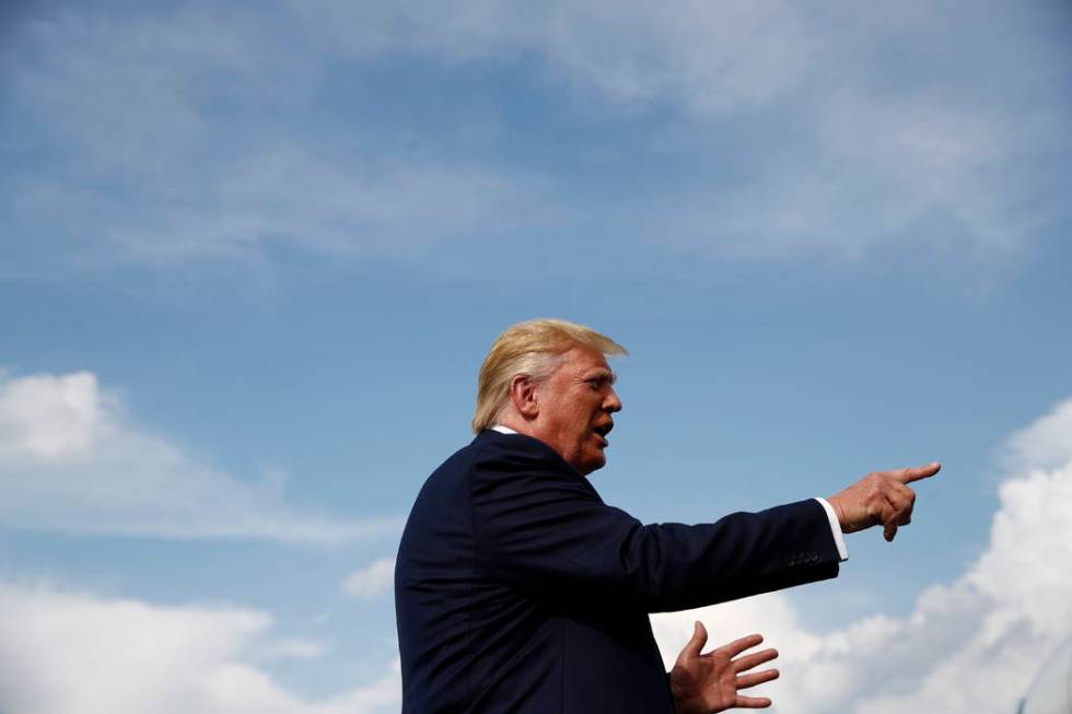 President Donald Trump speaks with reporters before boarding Air Force One at Morristown Munici ...