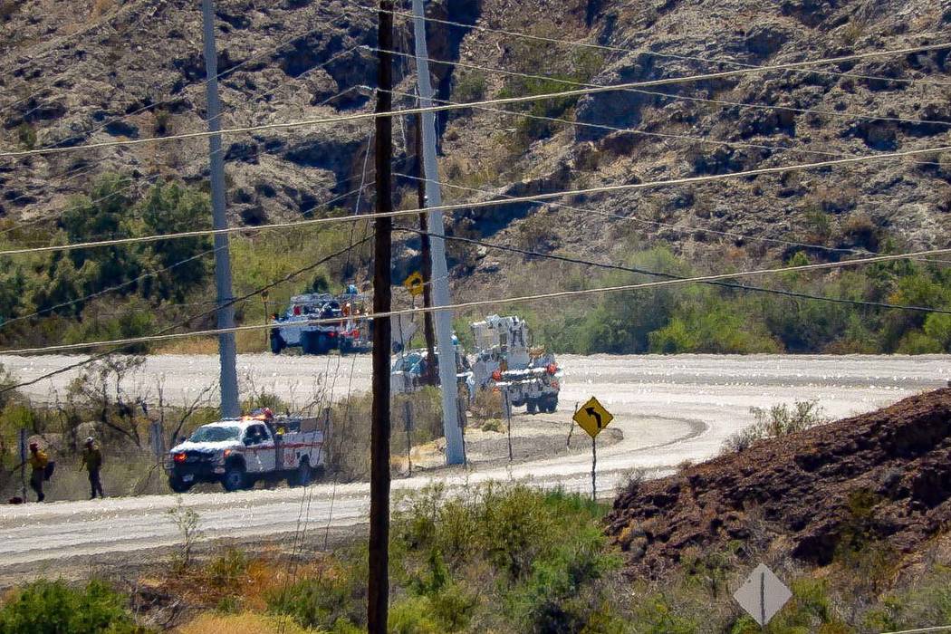 Crews make repairs to power lines in a burned area from the fire at Big Bend of the Colorado St ...