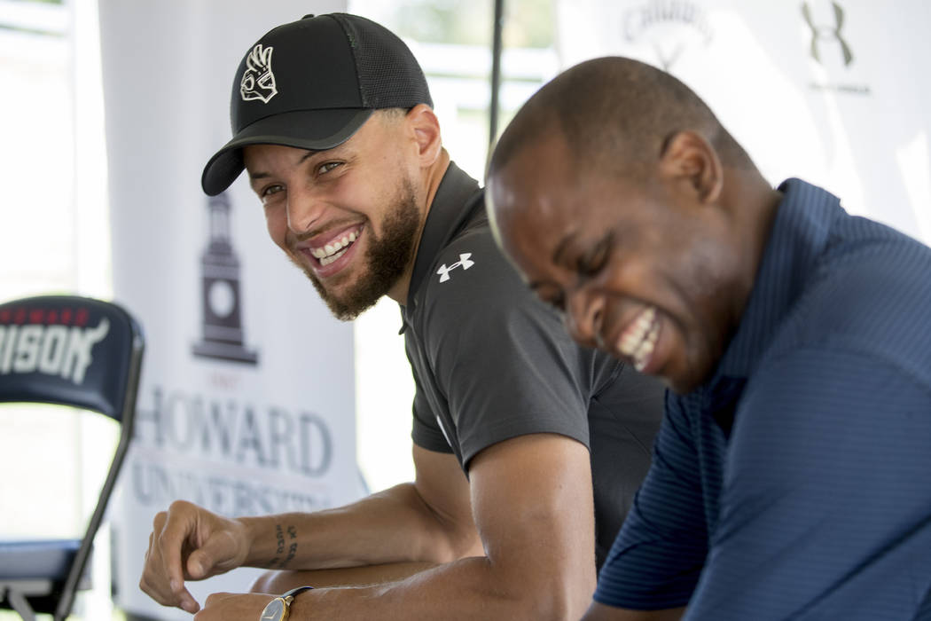 Golden State Warriors guard Stephen Curry, left, and Howard University president Wayne Frederic ...