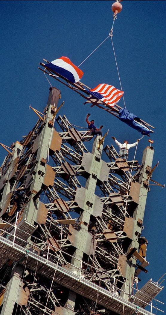 Iron workers topped off the Eiffel Tower at Paris-Las Vegas with a final, flag-fastened beam on ...