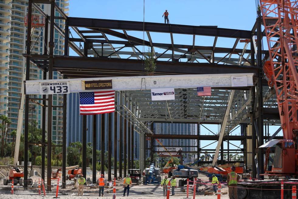 Workers hoist the last high beam on top of the future Las Vegas Convention Center exhibit hall ...