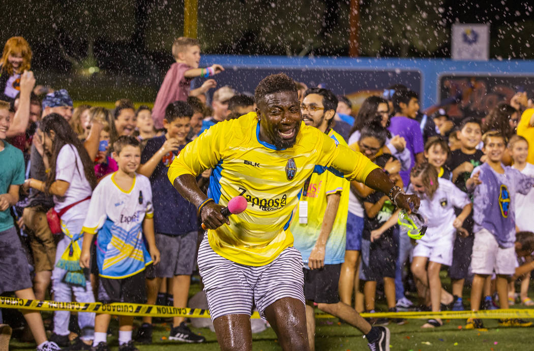 Las Vegas Lights FC hype man Bojo Ackah is pelted as he escapes the fans on field during a mass ...