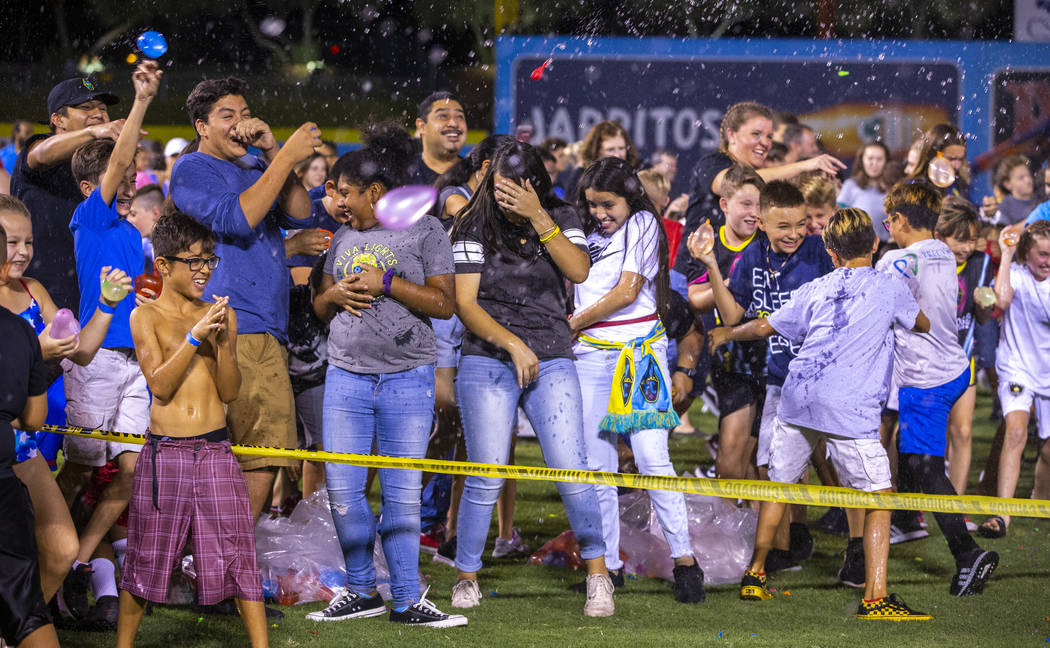 Las Vegas Lights FC fans enjoy a massive water balloon fight on field at halftime during their ...