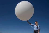Meteorologist Chelsea Kryston prepares to launch a balloon carrying a radiosonde that collects ...